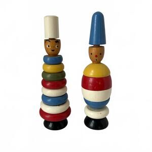 Vintage wooden stacking toys with painted heads and colorful rings.